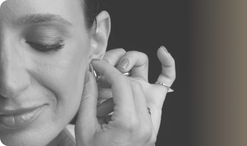 Detalhe em preto e branco de Daniela ajustando o brinco